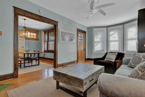 Relax in this inviting living space with a comfortable sofa, dining area, and wooden coffee table.