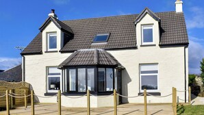 A two-story house with a gabled roof, a conservatory, and a fenced outdoor area. - 4 bedroom accommodation in West Bennan, near Shannochie (West Bennan, near Shannochie)