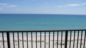 Een uitzicht op het strand met een balustrade op de voorgrond.