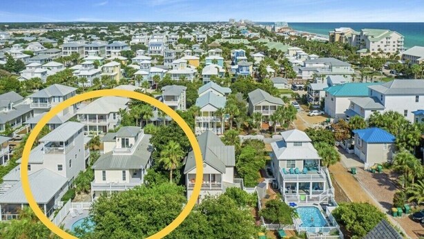 Un quartier résidentiel situé sur la côte, avec des maisons, une piscine et une vue sur l’océan.