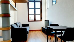 Una sala de estar moderna con un sofá, una mesa de comedor y un televisor.