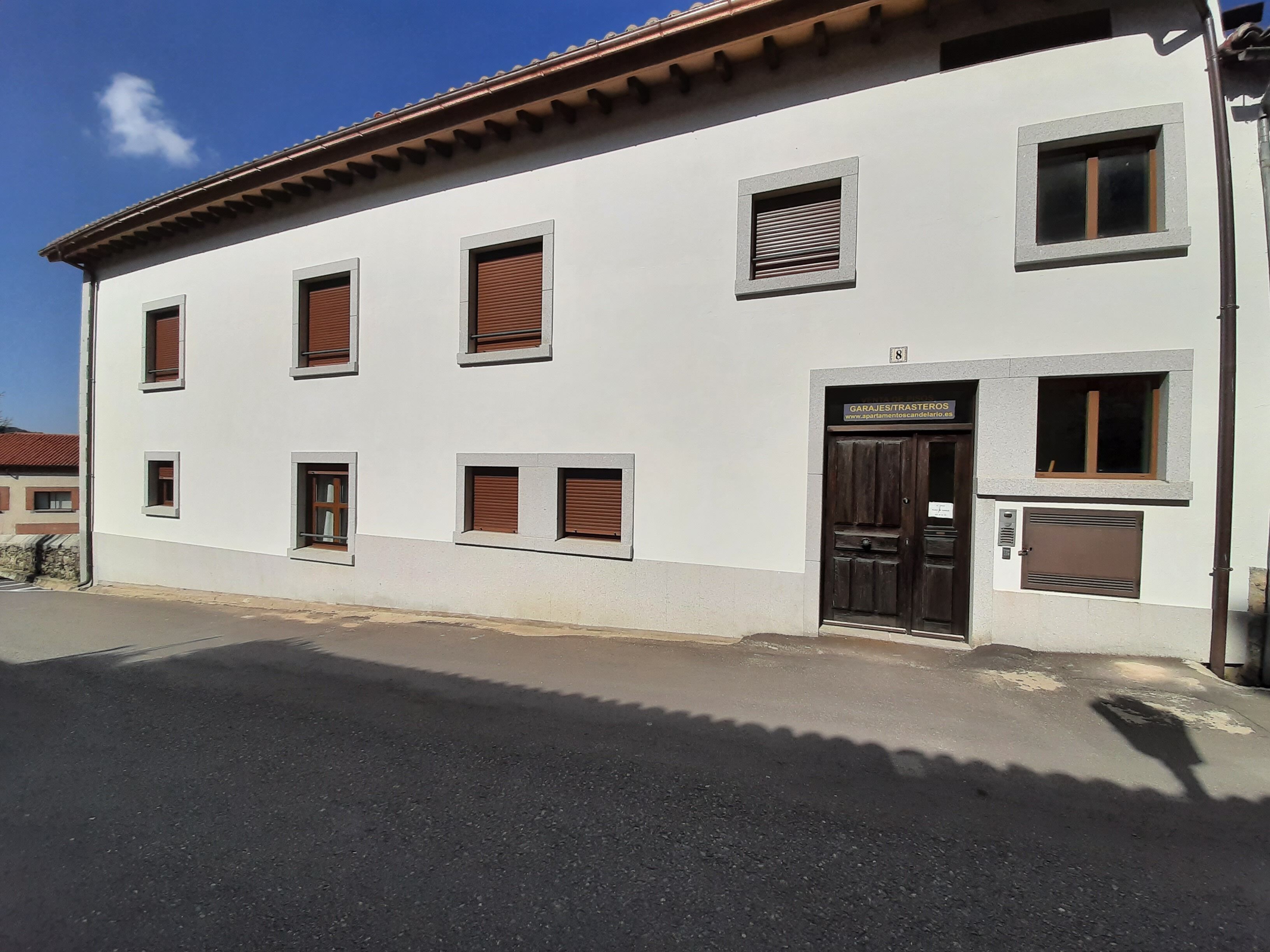 A white building with multiple windows and a door labeled "GARJES/STRATEROS".
