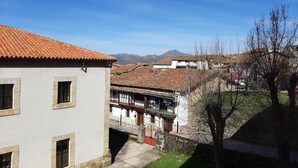 Un edificio tradicional con tejado de tejas, fachada de piedra y un pequeño patio.