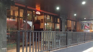 Un restaurante con un letrero que dice 'Cocktail Fruit', un letrero de 'Habitación en alquiler' y un letrero de 'Bienvenido'.