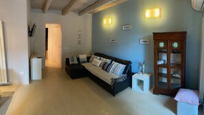 Een woonkamer met een bank, een kast en wandlampen.
