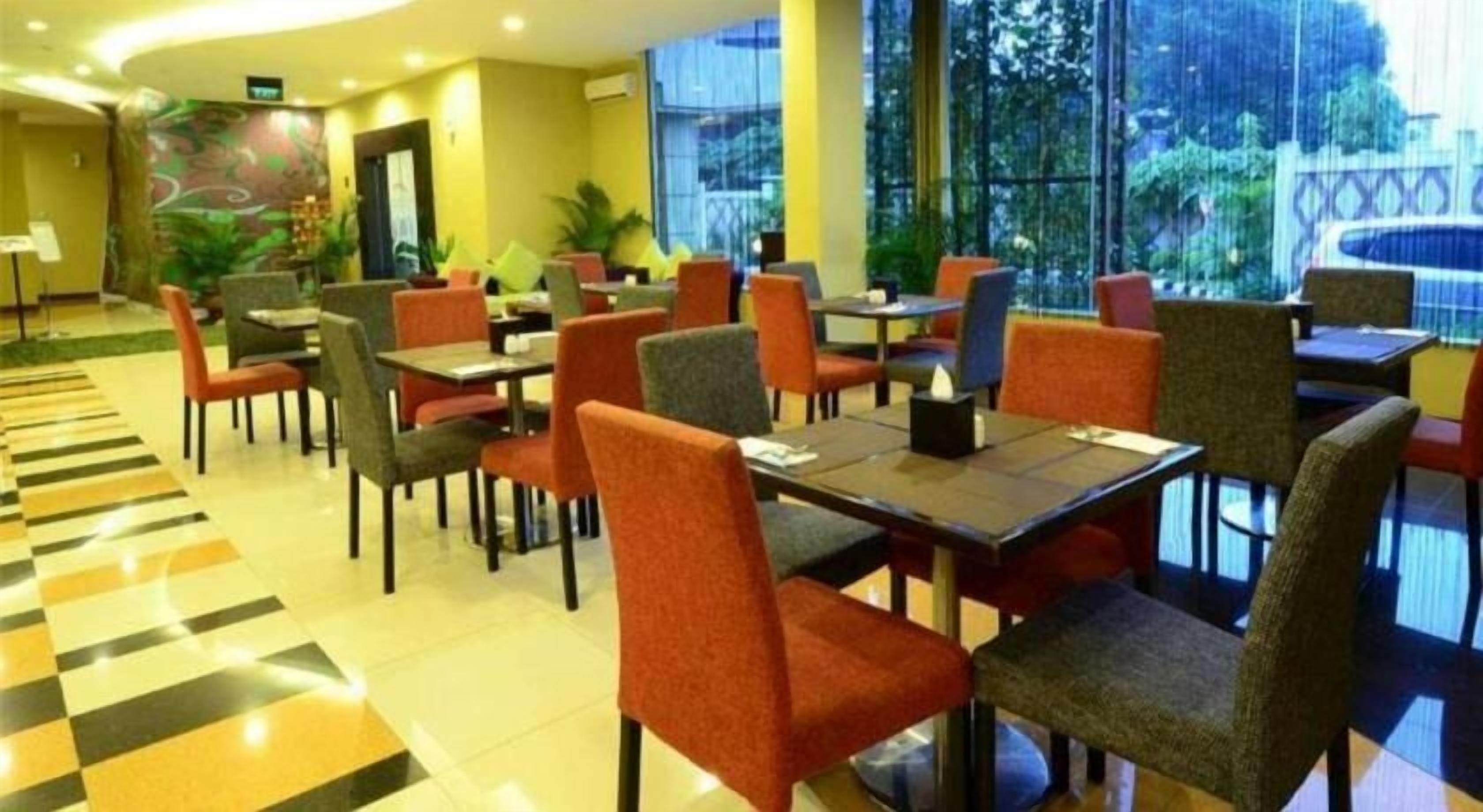 A restaurant with a checkered floor, multiple tables, and chairs.
