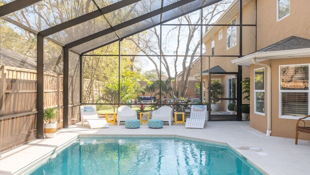A covered outdoor swimming pool with lounge chairs and a pergola structure. - 7BD 6BA, Pool&Spa, Walk to Beach, PutPut, Dream Backyard, 10 min. to Downtown!  (St. Augustine)