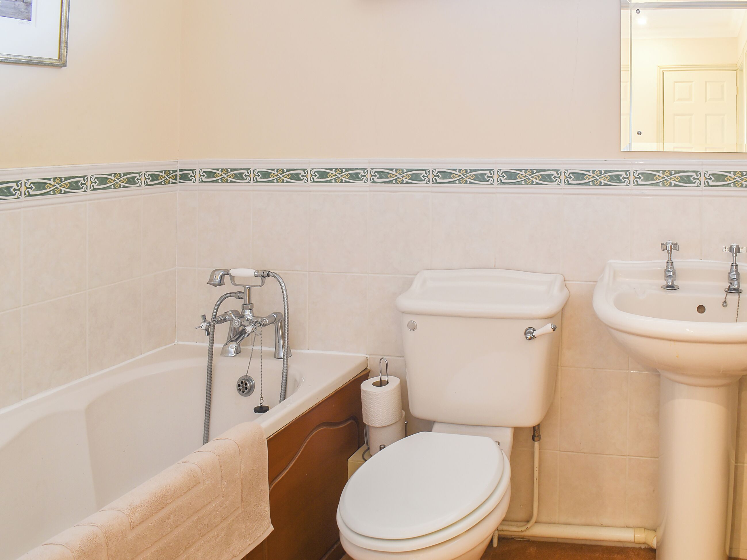 A bathroom with a bathtub, toilet, and sink.