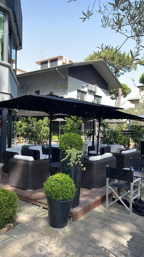 An outdoor seating area with wicker furniture and potted plants. - Casa Major Hotel & Appartamenti Cervia (Cervia)