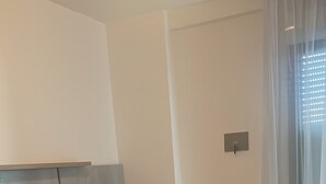 A hotel room with two beds, a chair, and a window with curtains. - Casa Major Hotel & Appartamenti Cervia (Cervia)