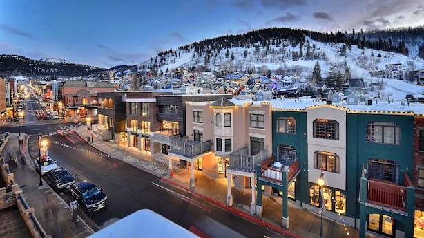 Une ville avec des bâtiments qui bordent une rue, certains étant dotés de balcons et d’éclairages.