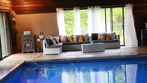 A poolside area with a seating arrangement and a built-in heater. - ***OASIS*** (Ingersoll)