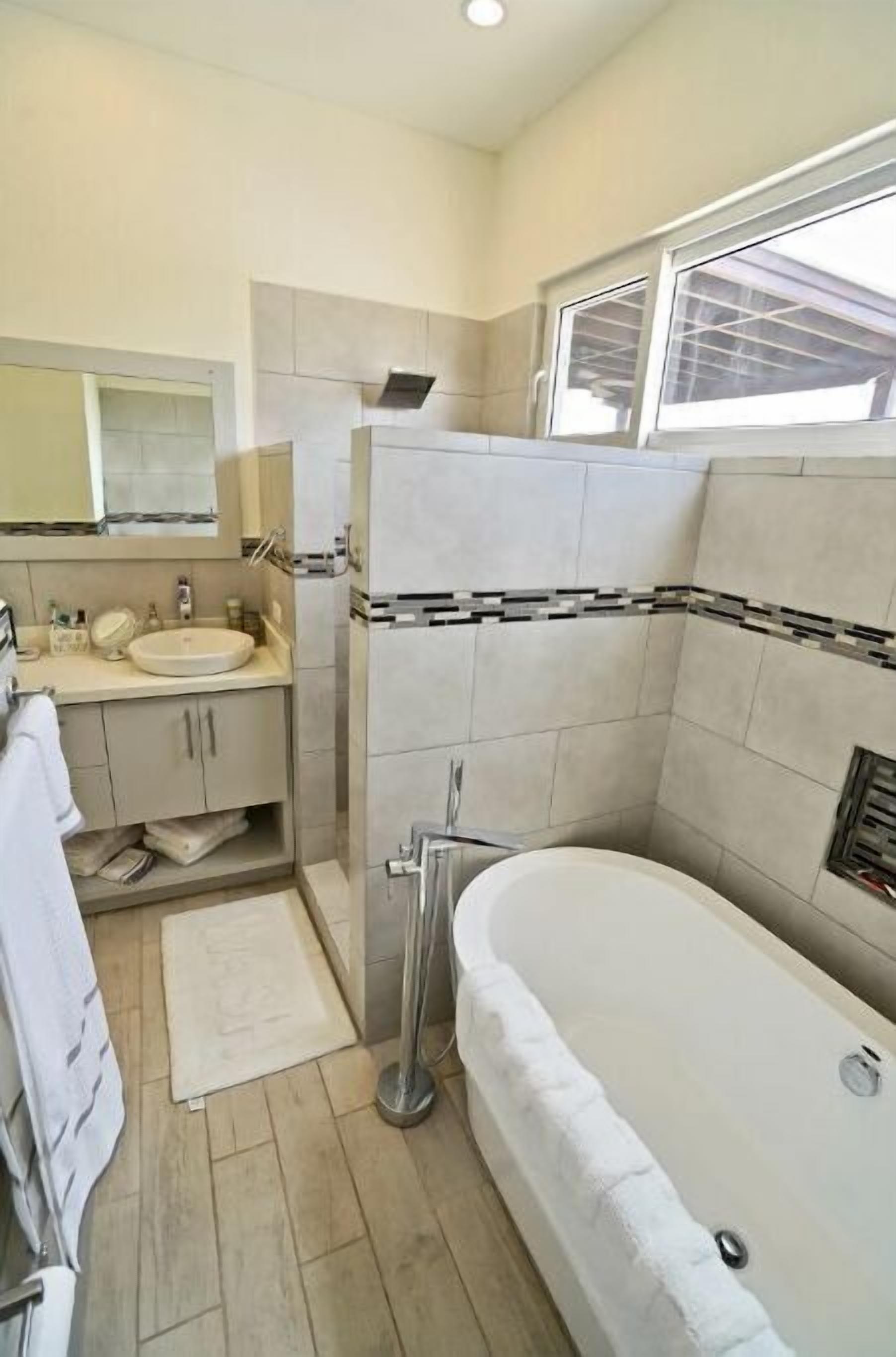 Un baño moderno con bañera, lavamanos y zona de ducha.