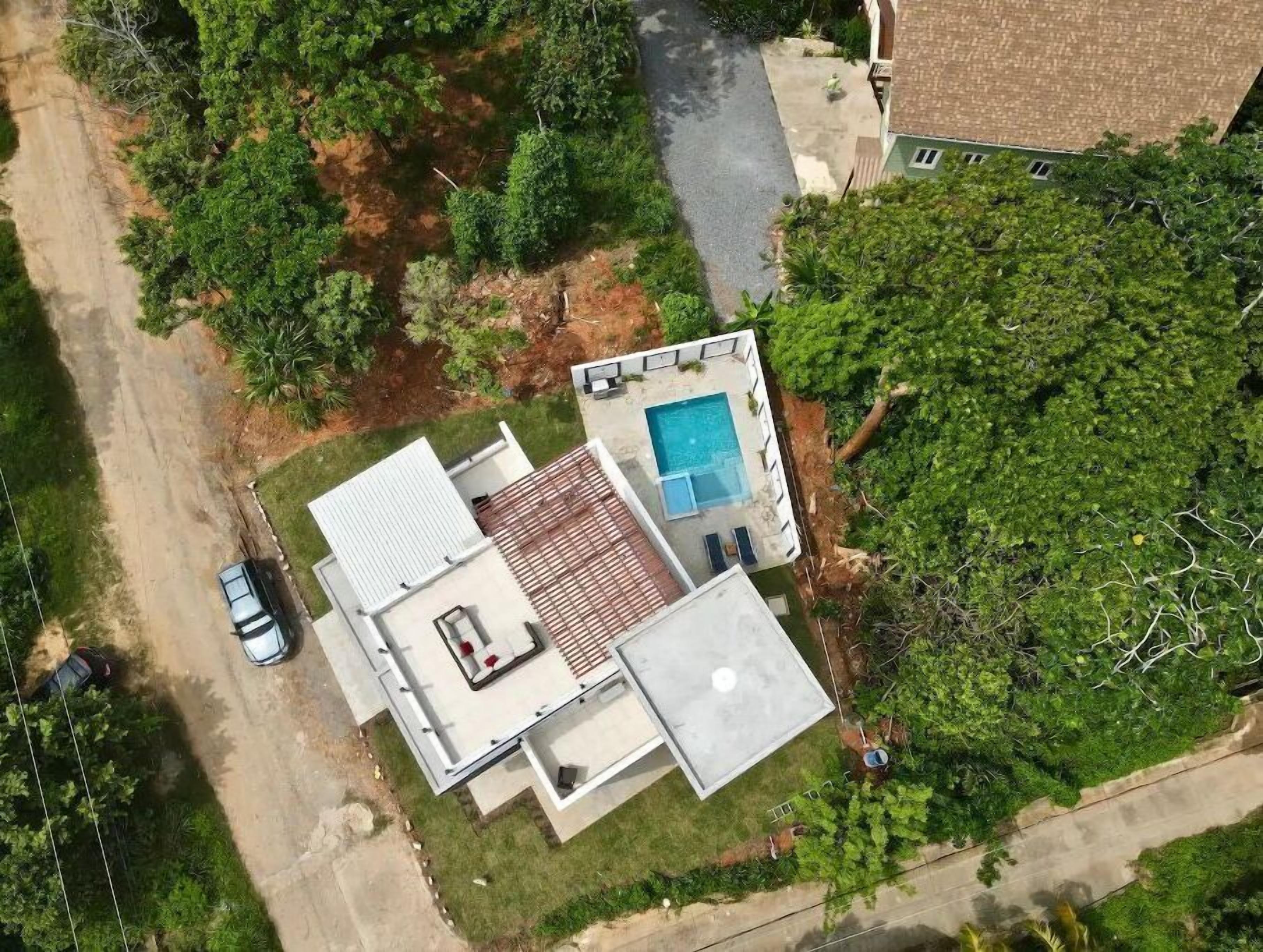 Vista aérea de uma casa com piscina, um pátio e uma garagem.