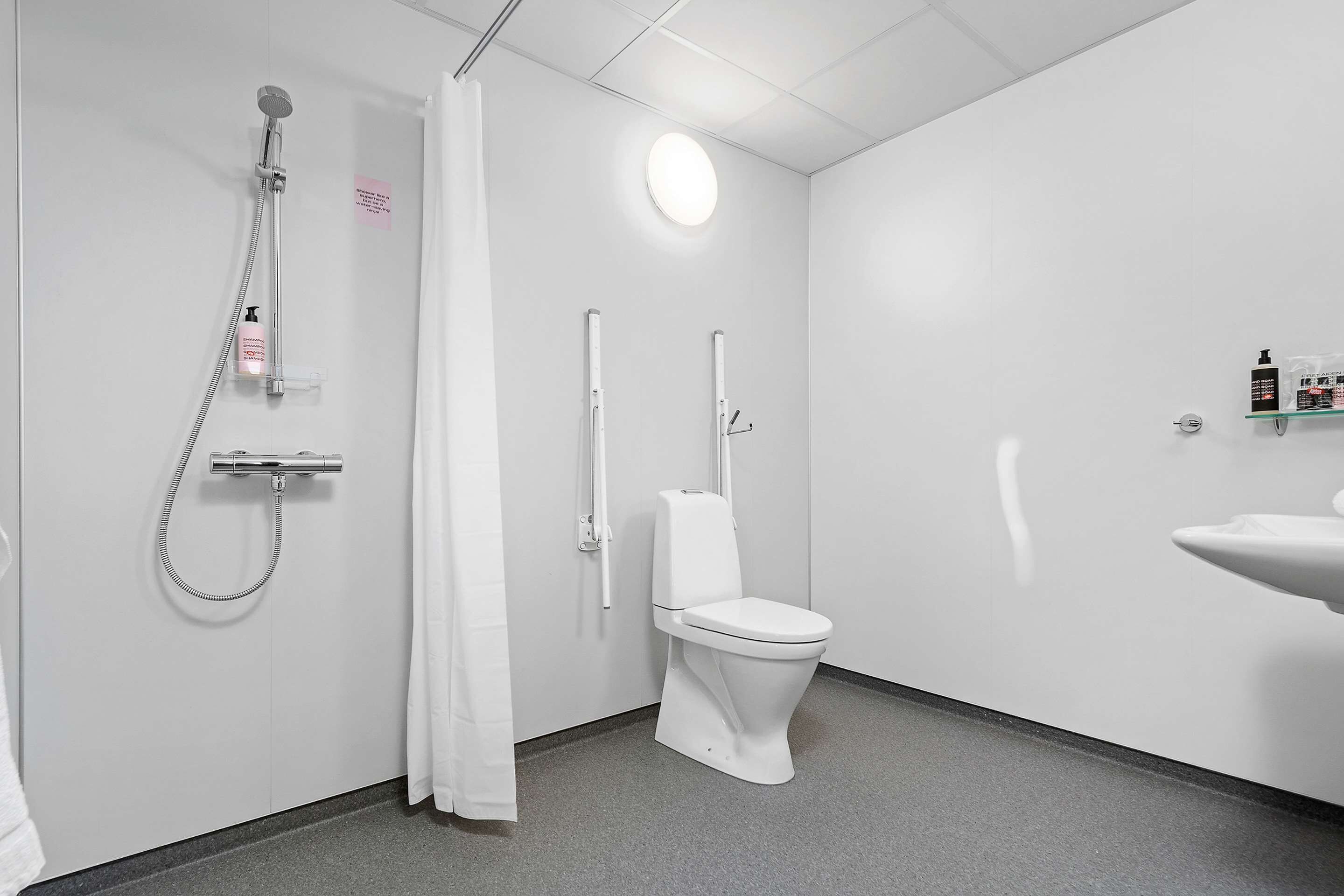 A modern bathroom with a shower, toilet, and sink.
