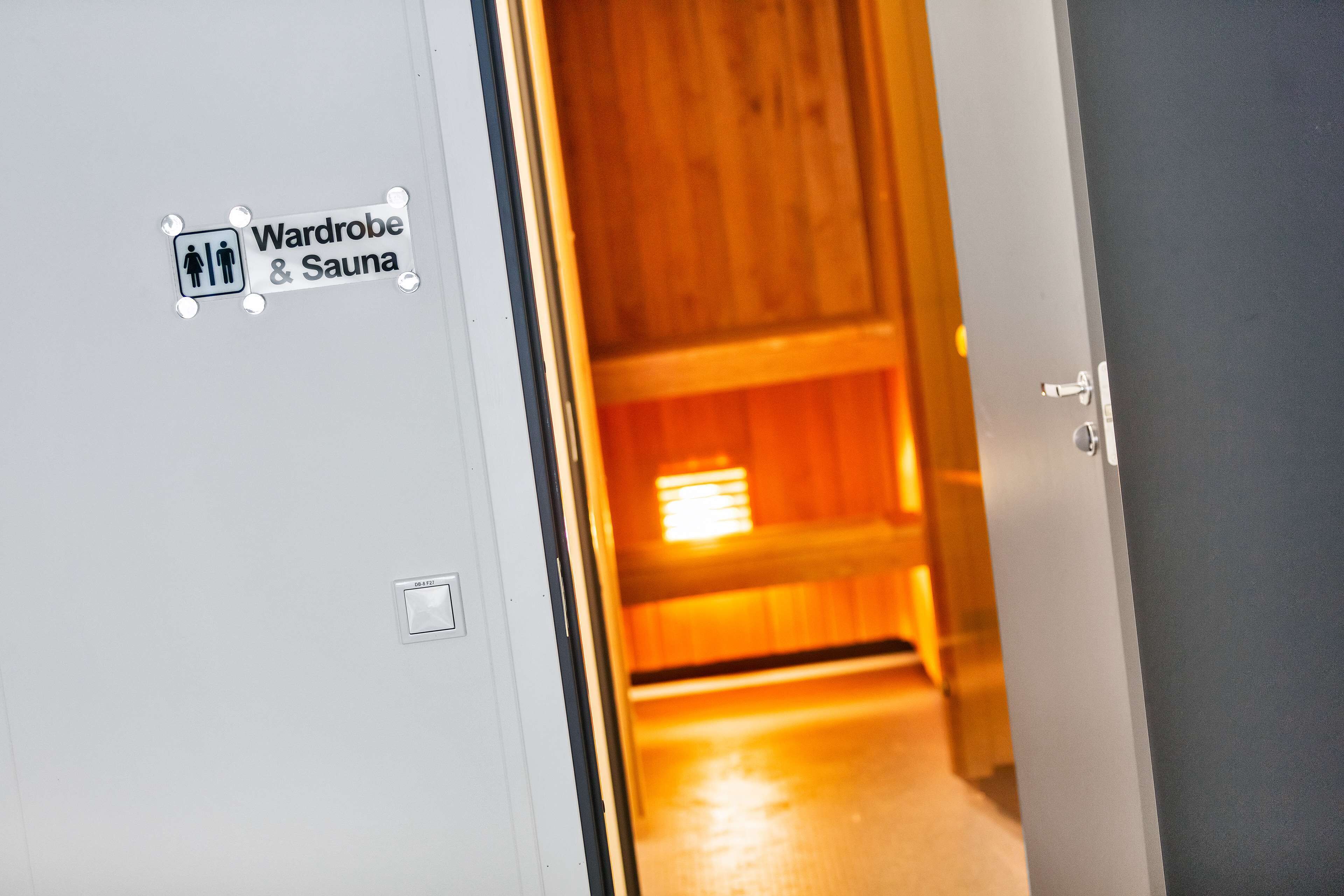 A door with a sign indicating a wardrobe and sauna.