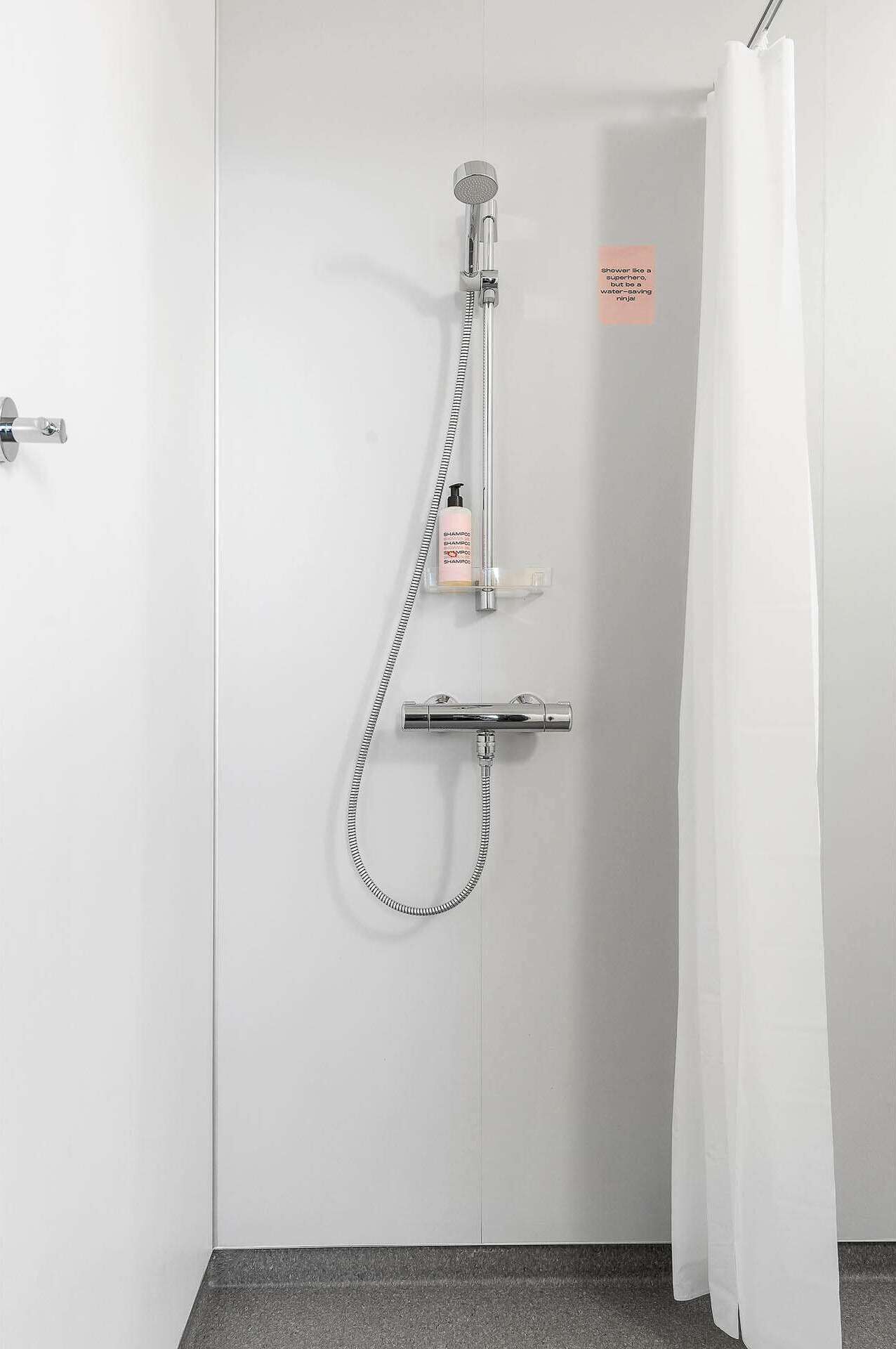 A shower with a handheld showerhead and a handheld shower attachment.
