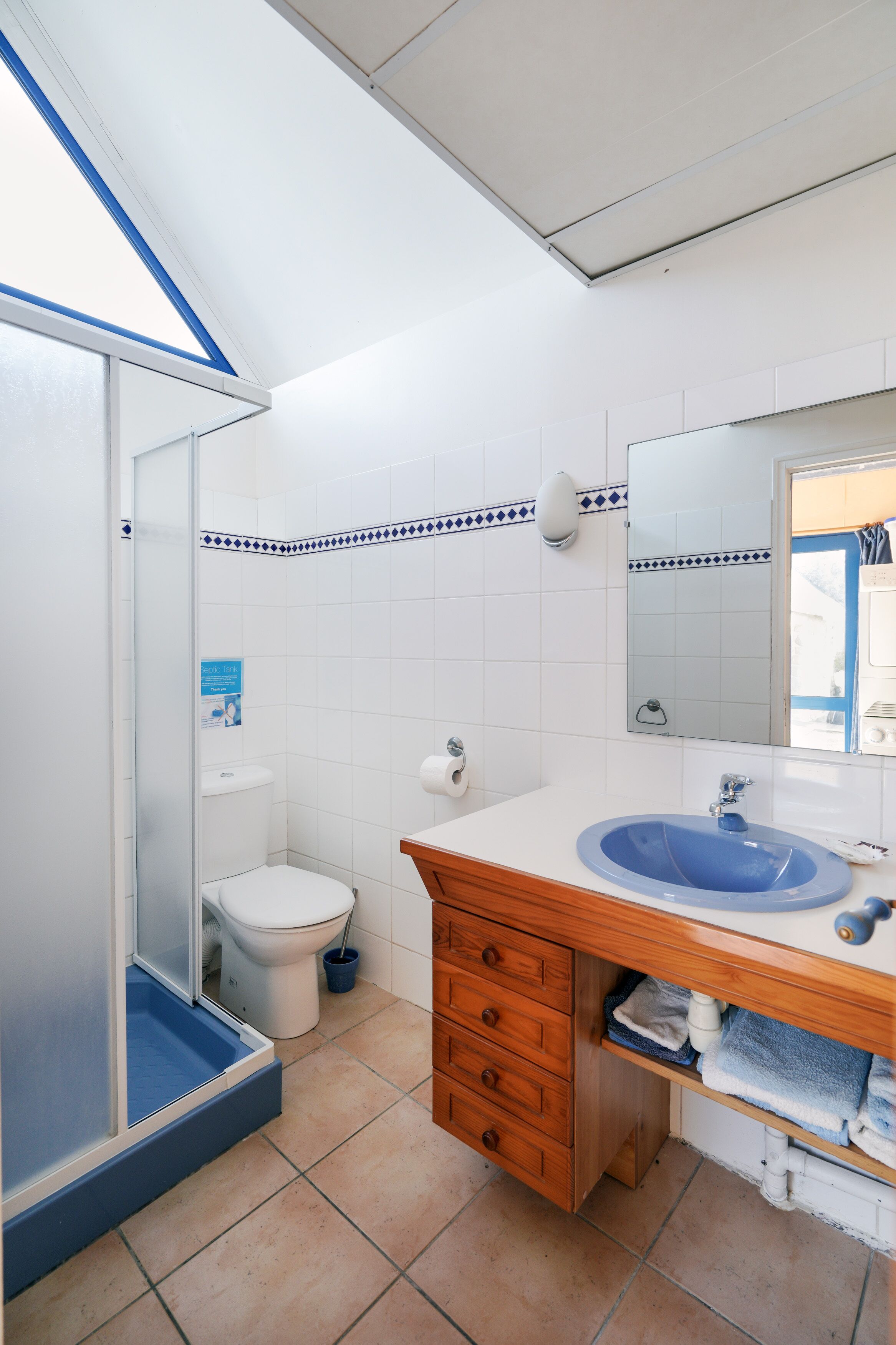 Une salle de bain équipée d’une douche, de toilettes, d’un lavabo et d’un miroir.