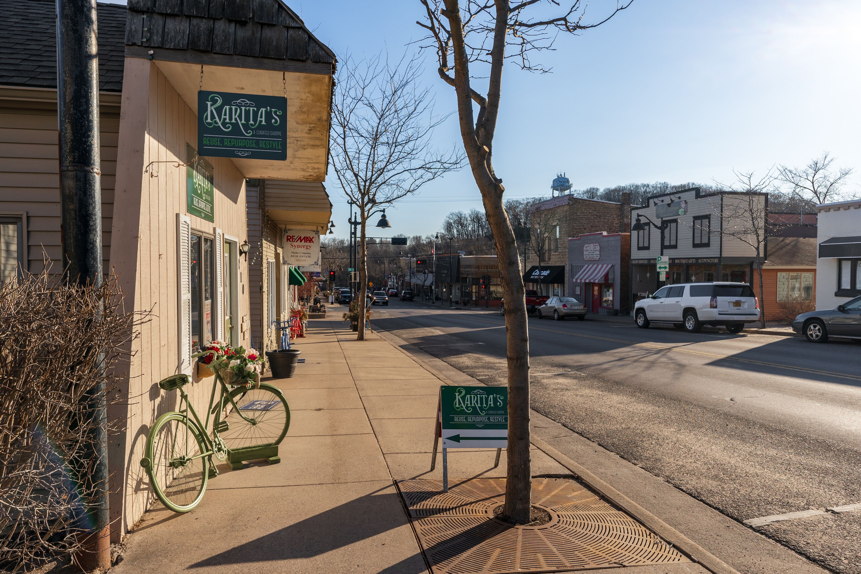 A street view with storefronts, a bicycle, and a directional sign.