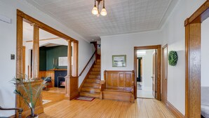 Ein geräumiger Wohnbereich mit Holzböden, einer Treppe und einem Kamin.