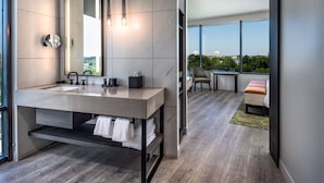 Un baño moderno con un espejo grande, lavamanos dobles y un perchero para toallas.