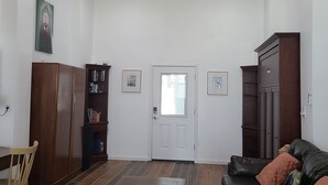 Un soggiorno con ventilatore a soffitto, un tavolo da pranzo, un divano e una libreria.