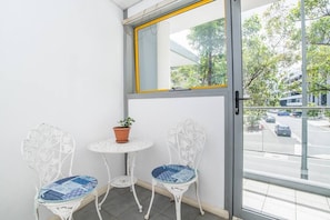 Enjoy the view from this balcony with a street view, featuring a table and chairs.