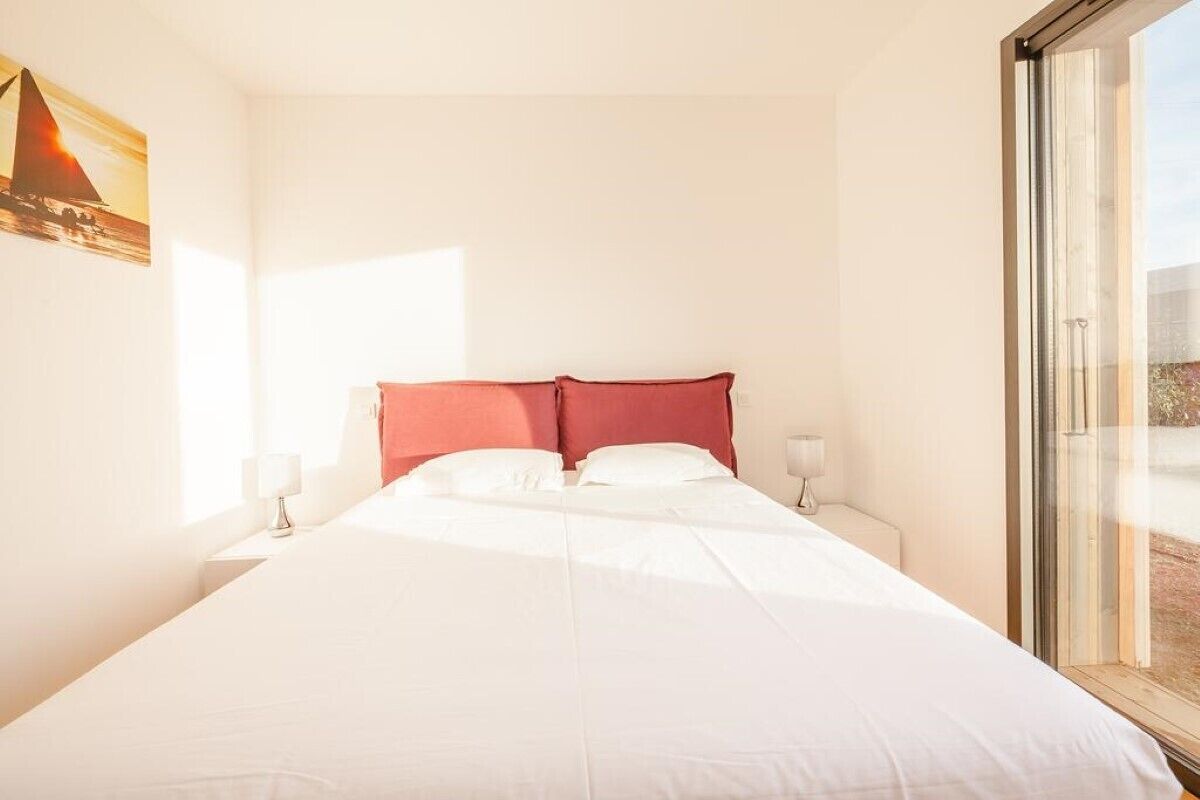 Ein Hotelzimmer mit einem großen Bett, einem Fenster und einem Gemälde an der Wand.