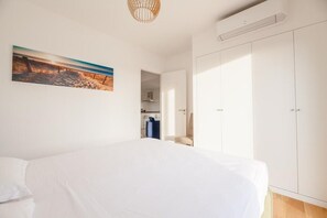 Um quarto com uma cama grande, um guarda-roupa e um quadro na parede.