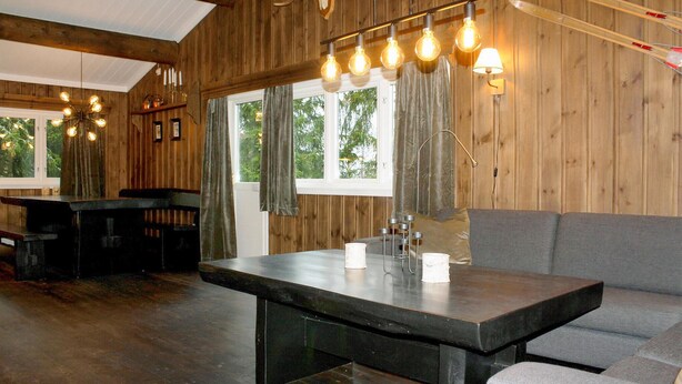 A rustic wooden interior with a dining table, seating, and a large window. - Stunning apartment in Hemsedal (Hemsedal)