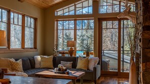 A cozy living room with a large sectional sofa, a coffee table, and a fireplace.