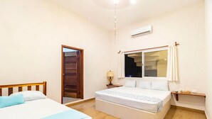 Une chambre d’hôtel équipée d’un lit, d’une table de chevet, d’une lampe, d’une fenêtre et d’un appareil de climatisation.