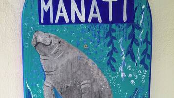 Un letrero en la pared con el texto 'SUITE MANATI' e ilustración de una manatí.