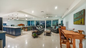 A spacious living area with a kitchen, dining area, and a large sliding glass door leading to an outdoor space.