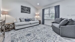 A modern living room with a grey sofa, a patterned rug, and a ceiling fan. - Fully Renovated Ranch Home 1/2 mi from Charming downtown Ball Ground (Ball Ground)