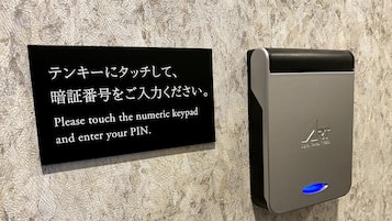 A digital keypad with instructions in both Japanese and English for entering a PIN.
