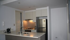 Uma cozinha moderna com ilha central, eletrodomésticos de aço inoxidável e forno embutido.