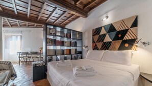 A bedroom with a large bed, a bookshelf, a desk, and a dining area. - Studio close by Piazza Navona - A/C - Wi-Fi - Washer (Roma)
