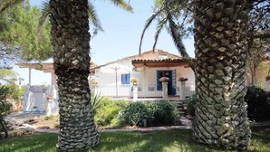 Una casa con un pilastro in pietra, facciata bianca e porta blu.