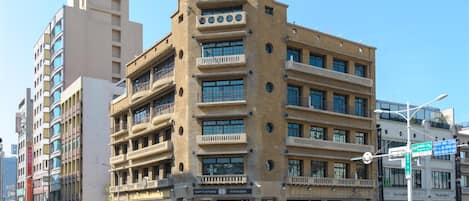 Un edificio de varios pisos con una entrada central, ventanas amplias y balcones.