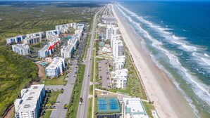 Zona residencial costera con edificios altos, una playa y una carretera.