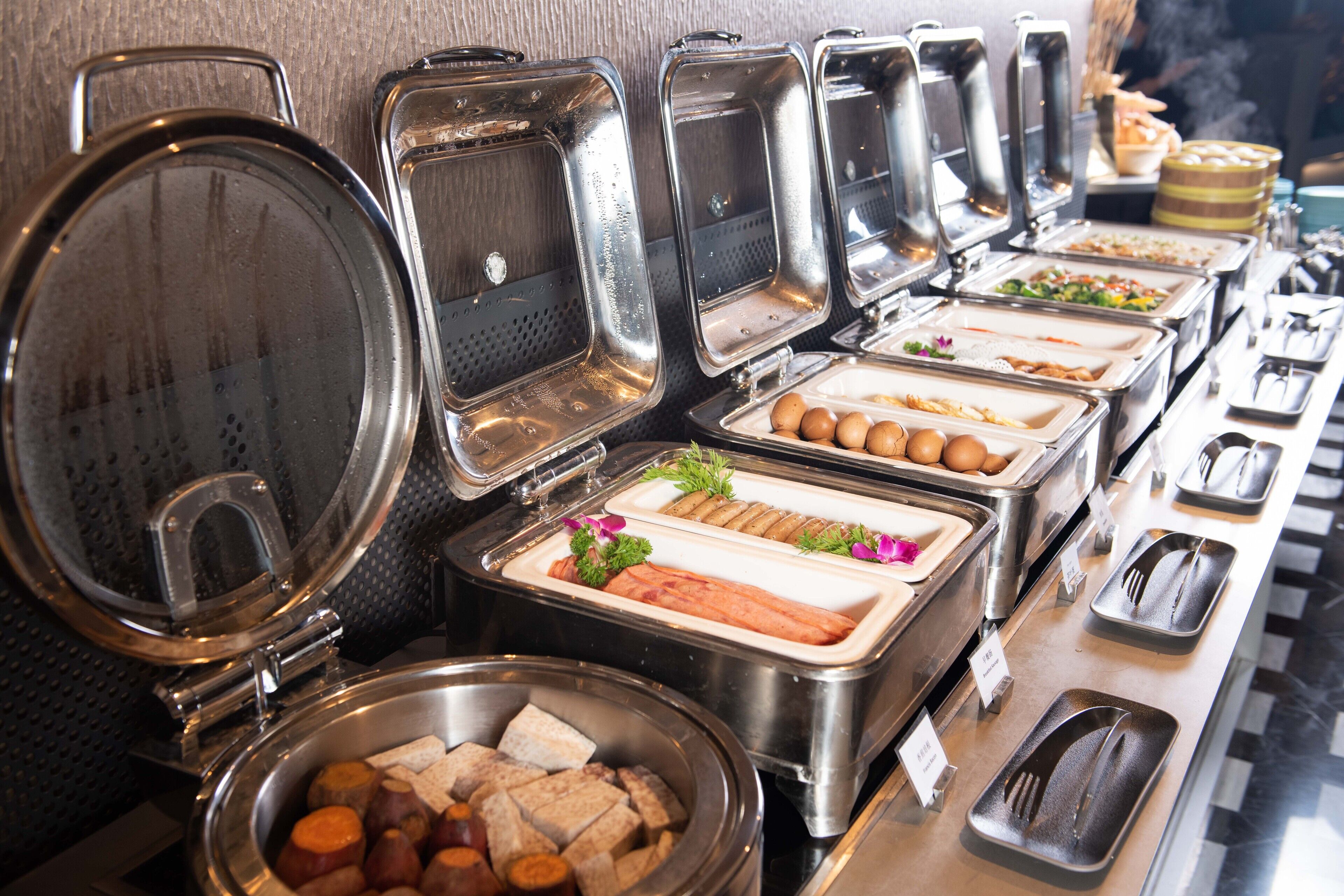 A buffet with various food items and utensils.