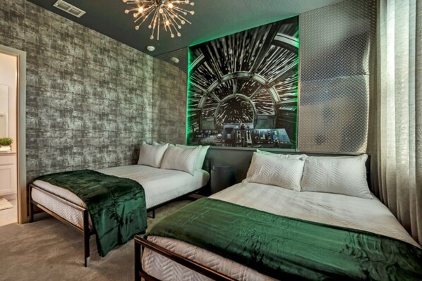 A hotel room with two beds, a modern chandelier, and a unique wall art piece.
