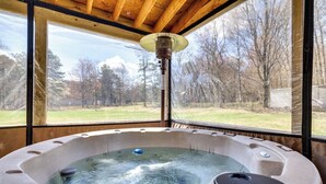 Un bain à remous avec vue sur une cour et des arbres.