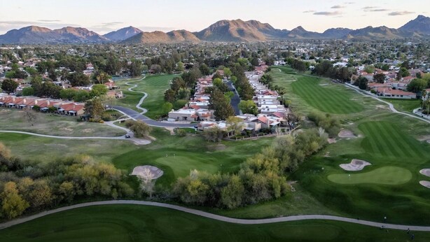 An aerial view of a golf course with residential buildings, roads, and mountains in the background. - Paradise Valley Paradise/ Ground Unit (Phoenix)