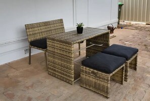 A wicker outdoor seating area with a table and two chairs, a small potted plant, and a basket. - Court House Hideaway by Your Innkeeper Mudgee (Mudgee)
