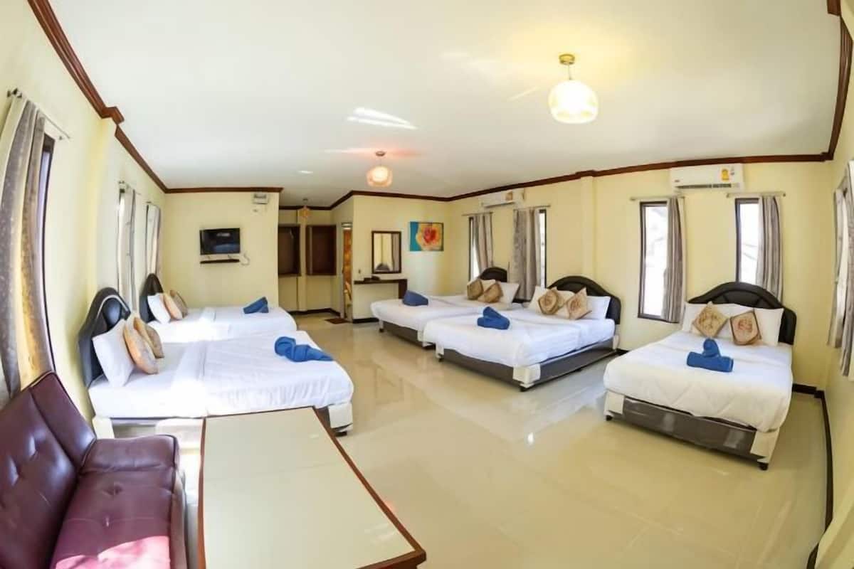 A hotel room with three beds, a sofa, and a TV.