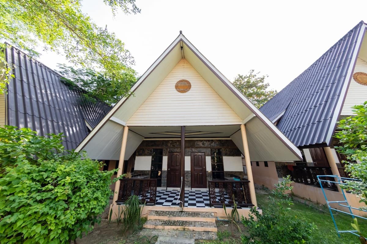 A building with a triangular roof, a checkered entrance, and a central door.