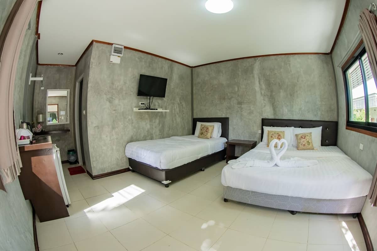 A hotel room with two beds, a TV, and a window.