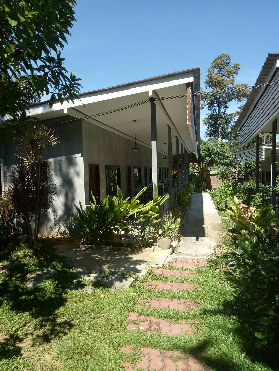 A covered outdoor area with a pathway leading to a building.
